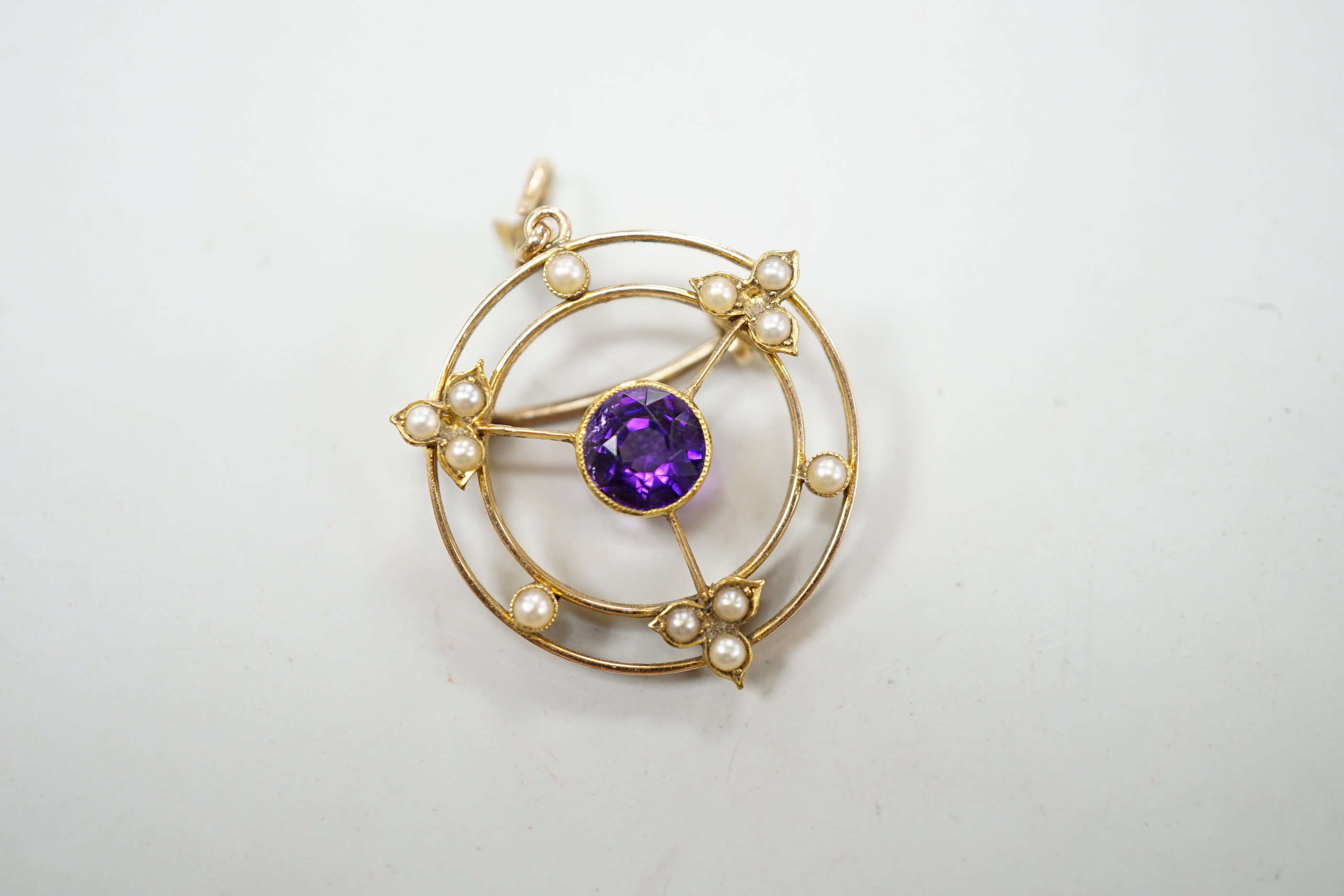 An Edwardian 15ct, amethyst and seed pearl set pendant brooch, overall 36mm, gross weight 4.1 grams, in fitted leather box.